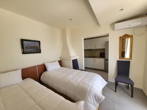 a bedroom with two beds and a chair in it at Sea & Relax Villa in Sarandë