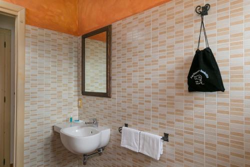 baño con lavabo y bolsa negra en la pared en Isolotto - Appartamento Quercia, en Piombino