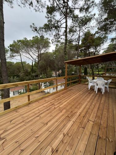 a wooden deck with a table and chairs on it at Camping Santa Elena in Lloret de Mar