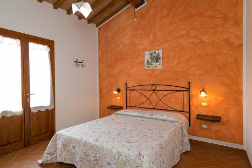 ピオンビーノにあるIsolotto - Appartamento Querciaのオレンジ色の壁のベッドルーム1室(ベッド1台付)