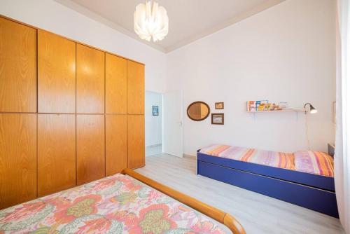 um quarto com uma cama, armários de madeira e um tapete em Giglio di Mare, Darsena Viareggio em Viareggio