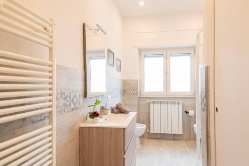 uma casa de banho branca com um lavatório e um WC em Giglio di Mare, Darsena Viareggio em Viareggio