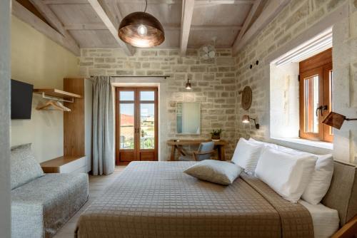 a bedroom with a bed and a couch at Pileas Villa, a Supreme Retreat by the Βeach, By ThinkVilla in Pigianos Kampos
