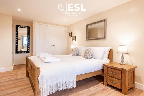 a bedroom with a large bed and a mirror at Modern, Sea Themed Ground Floor Flat Near Beach in New Quay