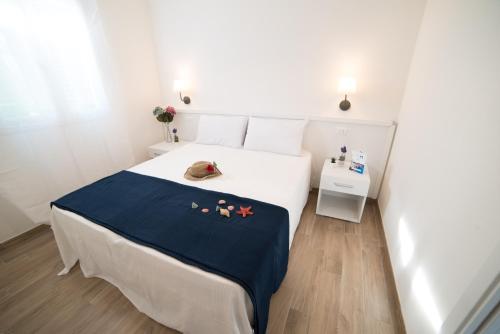 una camera con un letto bianco e una coperta blu di Appartamento Iremar C4 - MyHo Casa a Vieste