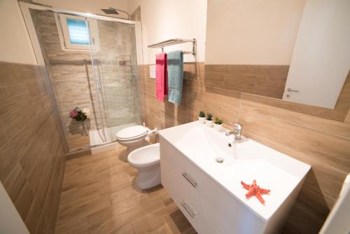 bagno con lavandino bianco e servizi igienici di Appartamento Iremar C4 - MyHo Casa a Vieste