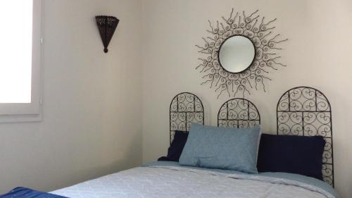 Schlafzimmer mit einem Bett und einem Wandspiegel in der Unterkunft T2 Proche Capelan -parking privé gratuit - wifi in Bandol