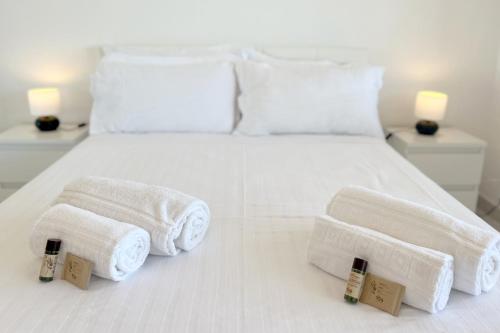 ein Schlafzimmer mit zwei Handtüchern auf einem weißen Bett in der Unterkunft Studio on Alvor's Beach by amcf in Alvor