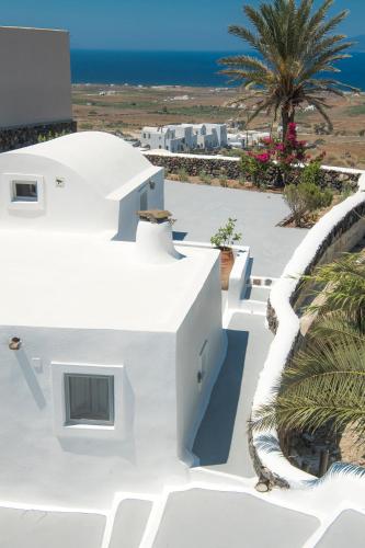 a white house with a view of the ocean at AQUA SERENITY LUXURY SUITES SANTORINI in Foinikiá