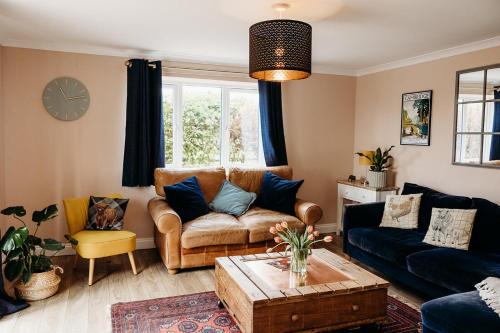 a living room with a couch and a table at Rodham House, Fenland Retreats at Willow Grange Farm in Cambridge