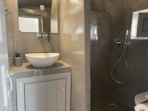 a bathroom with a sink and a shower at AQUA SERENITY LUXURY SUITES SANTORINI in Foinikiá