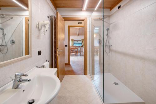 a bathroom with a sink and a glass shower at Chalet Anna Botton d'oro in Livigno