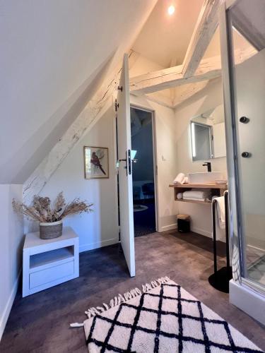 Cette chambre mansardée dispose d'une porte menant à une salle de bains. dans l'établissement Demeure de Flore - Hôtel Particulier au Cœur de Brive comprenant 8 appartements de charme, à Brive-la-Gaillarde