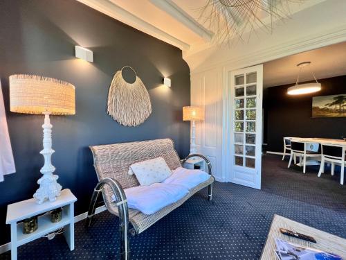 a living room with a chair and a table at Demeure de Flore - Hôtel Particulier au Cœur de Brive comprenant 8 appartements de charme in Brive-la-Gaillarde