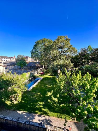 - une vue sur un parc arboré et une piscine dans l'établissement Demeure de Flore - Hôtel Particulier au Cœur de Brive comprenant 8 appartements de charme, à Brive-la-Gaillarde