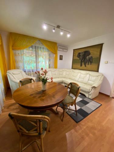 a living room with a table and a white couch at Fehér Hattyú Panzió in Orosháza