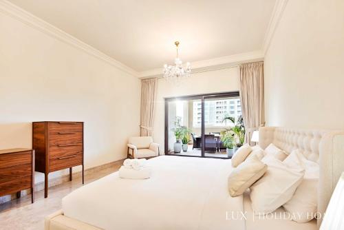 A bed or beds in a room at LUX The Elegant Fairmont Palm Suite