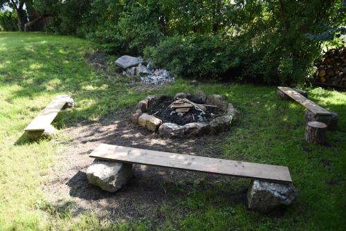 a fire pit with a bench in the grass at Vila Stecker - Zámeček pod Špičákem in Tanvald