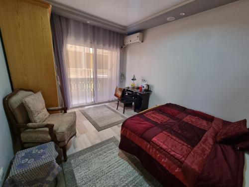 1 dormitorio con cama, silla y escritorio en Spring house, en Qaryat Shākūsh