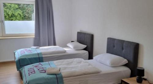 2 Betten in einem Zimmer mit Fenster in der Unterkunft Twitch Appartments in Achim