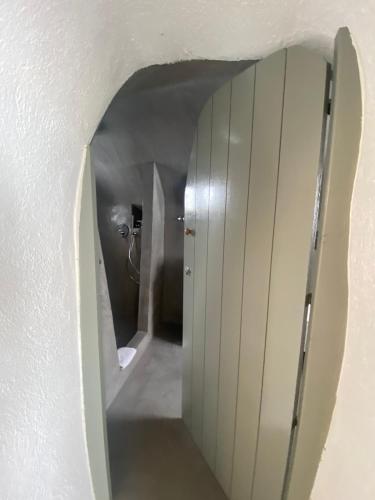 a hallway leading to a bathroom with a mirror at AQUA SERENITY LUXURY SUITES SANTORINI in Foinikiá