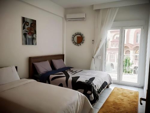 a bedroom with two beds and a window at Centrally Apartments in Xanthi
