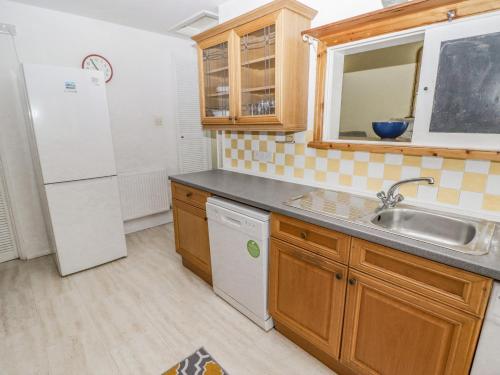 a kitchen with a sink and a refrigerator at Little Rosemount in Tenby