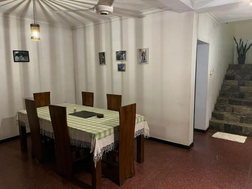 a dining room with a table and chairs and stairs at Rustic Mahaweli in Kandy