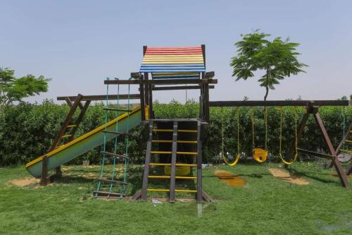 un parque infantil con un tobogán y una silla en شاليه غرفتين سوبر لوكس, en Dawwār ‘Abd Allāh