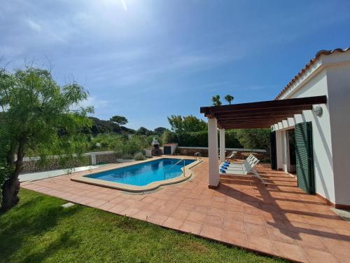 a backyard with a swimming pool and a house at Villa Xalina - Piscina / bbq / jardín in Fornells