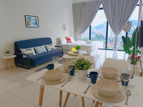 Rooftop Pool, Up to 8 Pax, 2 Bedrooms, 2 Bathrooms, 2 Car Parks by Star Home في جورج تاون: غرفة معيشة مع طاولة وأريكة زرقاء