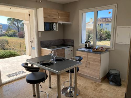 - une cuisine avec une table et deux tabourets dans l'établissement La paisible du Verdon, à Vinon-sur-Verdon