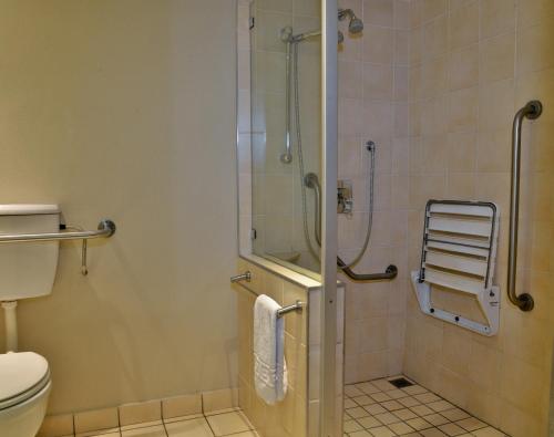 a bathroom with a shower and a toilet at Road Lodge Rivonia in Johannesburg