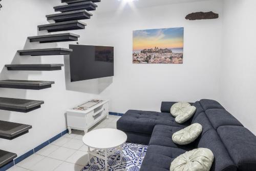 un soggiorno con un divano e una scala di La Bomboniera a Città di Lipari