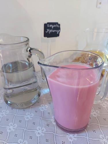a glass cup of pink liquid sitting on a table at Pousada do Pórtico in Gramado