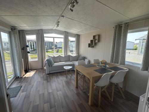 a living room with a couch and a table and chairs at NV 1013 - Beach Resort Nieuwvliet Bad in Nieuwvliet