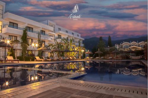 a hotel with a swimming pool at night at Palmonte Suites Hotel & SPA in Kyrenia