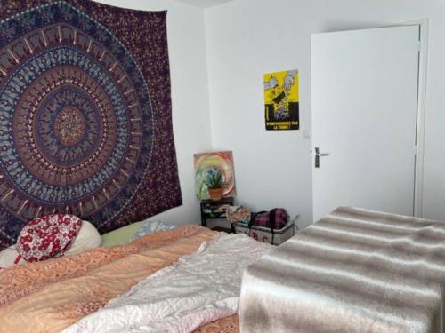 - une chambre avec un lit et un grand tapis sur le mur dans l'établissement Maison 6 chambres Paris, à Villejuif