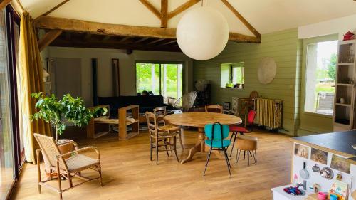 eine Küche und ein Esszimmer mit einem Tisch und Stühlen in der Unterkunft Chambre d'hôtes dans les champs in Jeux-lès-Bard