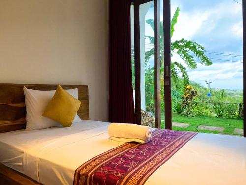 a bedroom with a bed with a large window at The Hill View Lombok in Kuta Lombok