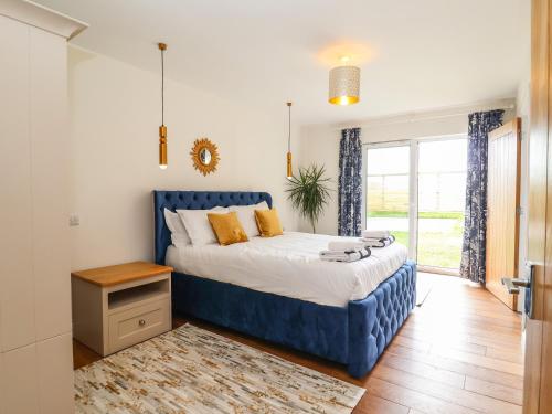 a bedroom with a blue bed and a window at Polly's Annexe in Ipswich