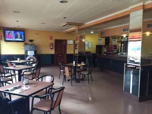 un restaurante con mesas y sillas y un bar en Hostal Tio Pepe I, en Bembibre