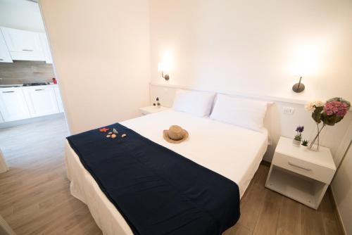 una camera da letto con un letto con un cappello sopra di Appartamento Iremar C3 - MyHo Casa a Vieste