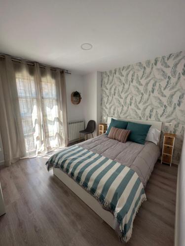 a bedroom with a large bed with a patterned wall at Apartamento Entre Ríos in Tudela