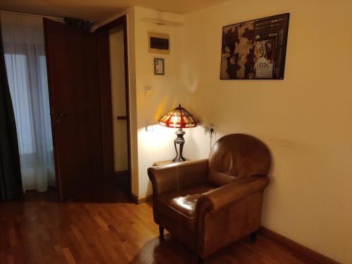 a living room with a brown chair and a lamp at Rembrandt Old Town in Bucharest