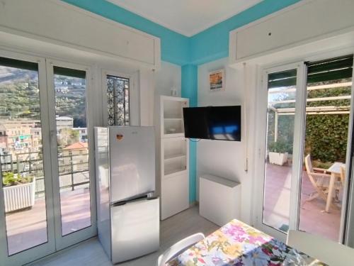 a living room with a refrigerator and a balcony at IL NIDO di NERVI in Genova