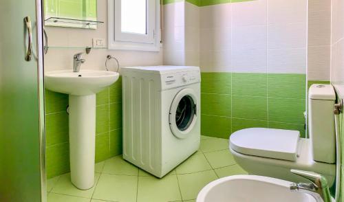 zieloną łazienkę z pralką i umywalką w obiekcie Endy Apartaments w mieście Orikum