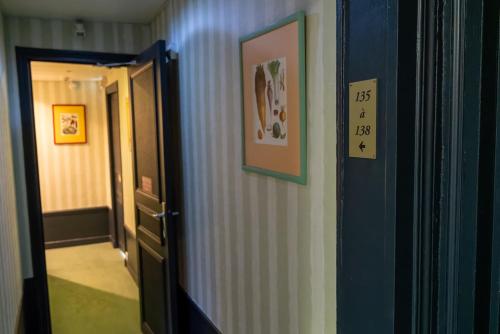 a hallway with a door and a picture on the wall at Nouvel Hôtel in Paris