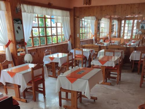 un comedor con mesas, sillas y ventanas en Kissandros Hotel en Agia Galini