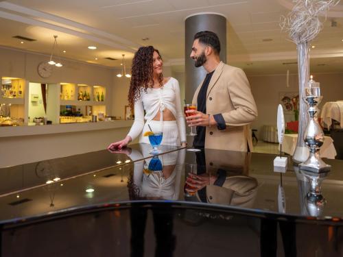 a man and a woman standing next to a table at Parc Hotel in Peschiera del Garda